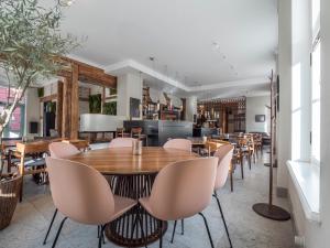 a dining room with wooden tables and chairs at Boutique Hotel Rosenplänter in Pärnu