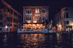 a building on a canal in a city at night at Hotel Palazzo Stern in Venice