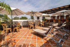 a patio with tables and chairs and umbrellas at Puerta San Pedro in Guadalajara