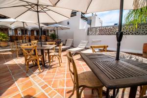 un patio al aire libre con mesas, sillas y sombrillas en Puerta San Pedro, en Guadalajara