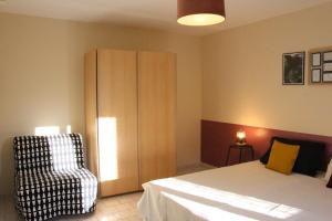 1 dormitorio con 1 cama, armario y silla en le p'tit cauxtier, en Senneville-sur-Fécamp