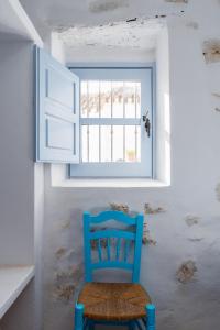 a blue chair sitting in front of a window at Casa Higueras in Moclín
