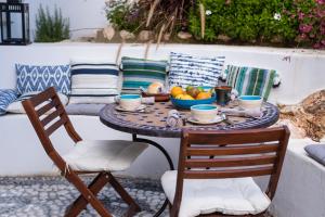 a table with a bowl of fruit and two chairs at Casa Higueras in Moclín