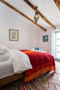 a bedroom with a bed with a colorful blanket at Casa Higueras in Moclín
