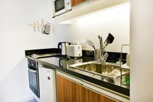cocina con fregadero y microondas en Moderno apartamento en Edificio One Torre 2, en Punta del Este