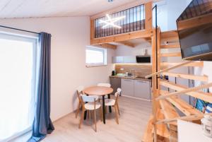 a small kitchen and dining room with a table in a tiny house at Matik Apartamenty i pokoje in Karwia