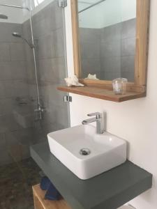 a bathroom with a white sink and a shower at Otium in Coteau Raffin +54 photos