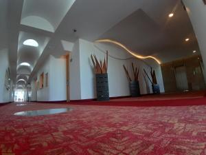 Cette grande chambre est dotée d'un tapis rouge et d'un mur avec des bâtons en bois. dans l'établissement AUTO HOTEL LEGARIA, à Mexico