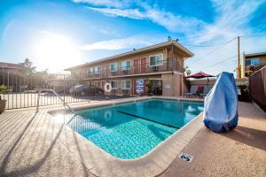 a swimming pool with a slide in front of a building at Friendly Hills Inn in Whittier