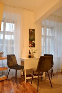 City-Maisonette في فيينا: غرفة طعام مع طاولة بيضاء وكرسيين