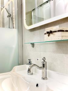 lavabo blanco con espejo y lavabo en City-Maisonette, en Viena
