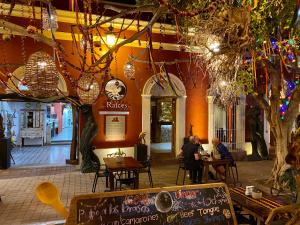 two people sitting at tables in a restaurant at Hotel Raices de Mar in Mazatlán
