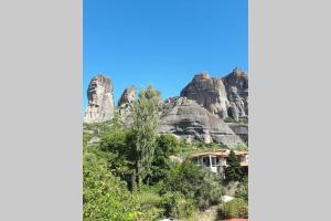 a house in front of a mountain at The house under the rocks of Meteora 1 in Kalabaka