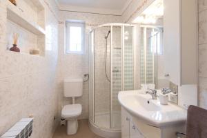 a bathroom with a shower and a sink and a toilet at Apartments Morozin in Krk