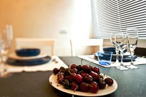 a plate of grapes on a table with wine glasses at Hotel Ferro di Cavallo in Pavullo nel Frignano