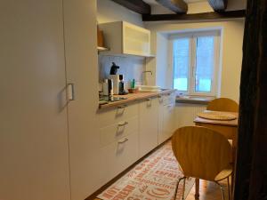 a kitchen with white cabinets and a table and a window at Paulusstrasse 1 in Ediger-Eller