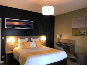 1 dormitorio con 1 cama grande con almohadas amarillas en Hôtel les 13 Assiettes, en Le Val-Saint-Père