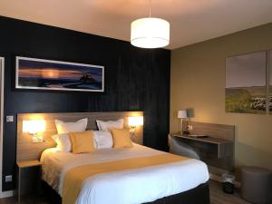 a bedroom with a large bed with yellow pillows at Hôtel les 13 Assiettes in Le Val-Saint-Père