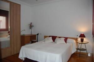 a bedroom with a large white bed and a table at La Casa de Lines in Monforte de Lemos