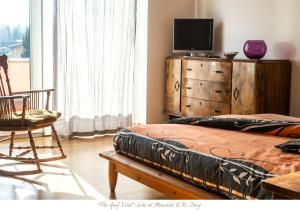 a bedroom with a bed and a dresser with a television at The Gulf Villa - Lago Maggiore in  Monvalle 
