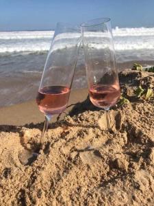 dois copos de vinho sentados na areia na praia em Glentana Silver Moon Self Catering em Glentana