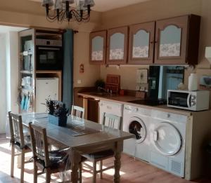 Montlevon的住宿－Les Bories en Champagne，厨房配有桌子和洗衣机。