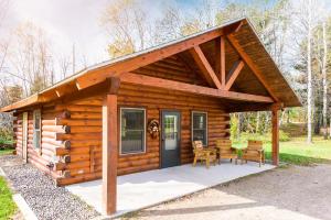 a log cabin with a porch and a table and chairs at Spur of the Moment Ranch in Mountain