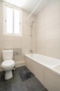 uma casa de banho branca com um WC e uma banheira em Versus Apartment City Center em Valência