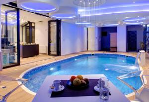 a large swimming pool with a plate of fruit on a table at Diamond Rain Boutique Hotel in Sarajevo
