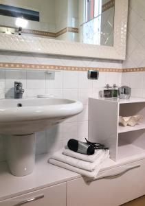 a bathroom with a sink and a mirror and towels at The Gulf Villa - Lago Maggiore in  Monvalle 