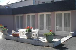a patio with a table and chairs and flowers at Auberge du Calvaire in Pontchâteau