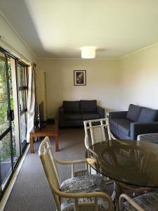 a living room with a couch and a table and chairs at Opua Boutique Seaview Motel in Opua