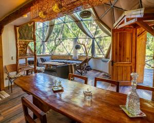 a dining room with a wooden table and large windows at Cascada de las Animas in San Alfonso