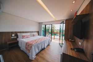 a bedroom with a bed and a flat screen tv at Pousada Morro do Farol in Fernando de Noronha