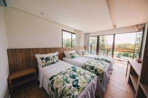 a bedroom with two beds and a balcony at Pousada Morro do Farol in Fernando de Noronha