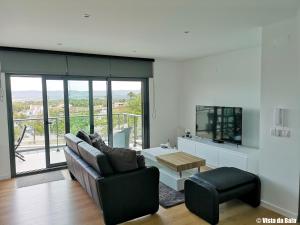 a living room with a couch and a tv at Vista da Baia in Salir de Porto