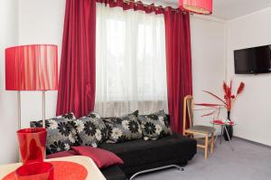 salon z czarną kanapą i czerwonymi zasłonami w obiekcie Vistula Hotel w mieście Świecie