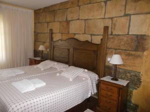 1 dormitorio con cama y pared de piedra en Hotel Rural El Rincón de Gadea, en Santa Gadea