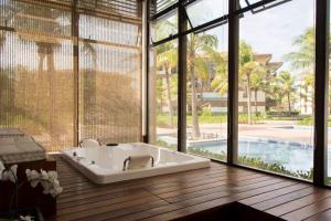 a bath tub in a room with large windows at Mandara Lanai in Aquiraz