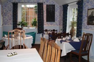 a dining room with tables and chairs and blue walls at The Old Red Lion in Thame