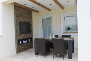 a dining room with a table and chairs and a tv at Apartments Martin - modern in Rovinjsko Selo