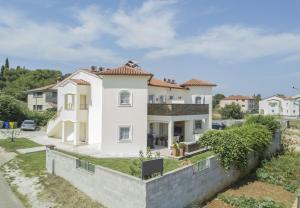 a large white house with a stone wall at Apartments Martin - modern in Rovinjsko Selo