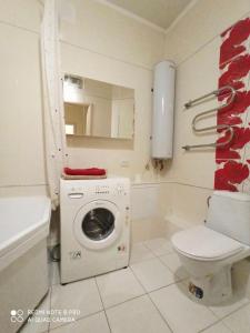 a bathroom with a washing machine and a toilet at Apartment in the center in Cherkasy