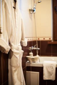 a bathroom with a white robe hanging next to a sink at Art-Rustic Boutique Hotel in Chişinău
