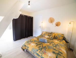 een slaapkamer met een bed met een kleurrijk dekbed bij "Le Cocon" - 3 chambres et terrasse, centre-ville in Castelsarrasin