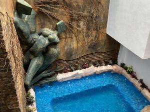 eine Statue einer Frau neben einem Schwimmbad in der Unterkunft Hotel Raices de Mar in Mazatlán