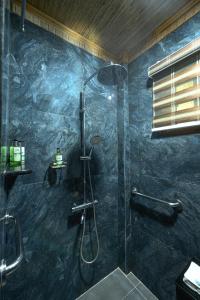 a bathroom with a shower with a glass door at Daluyon Beach and Mountain Resort in Sabang