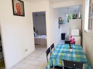 a dining room with a table and a refrigerator at Chez Ena la fibre internet et le calme in Saint-Claude