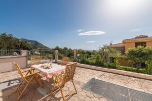 a table with a cat sitting on it on a patio at Holiday home in Cala Gonone 34685 in Cala Gonone