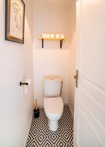 een badkamer met een toilet en een zwart-witte vloer bij "Le Cocon" - 3 chambres et terrasse, centre-ville in Castelsarrasin +4 foto's